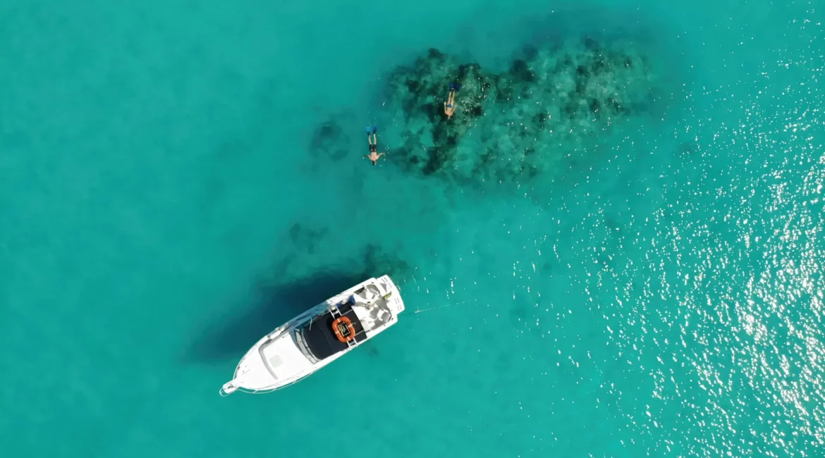 Bateau et baigneurs dans un lagon turquoise en Guadeloupe